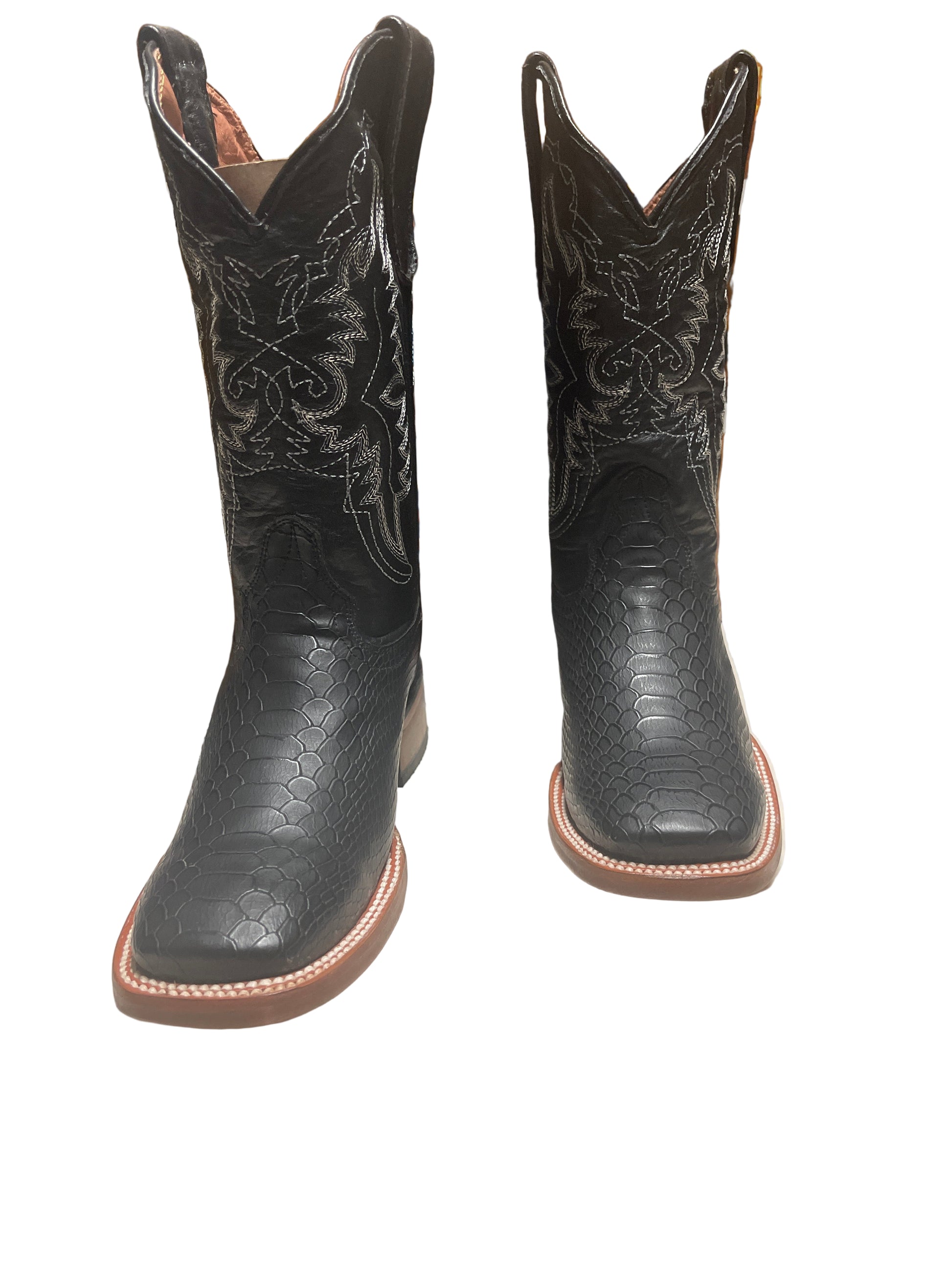 Pair of black leather cowboy boots with intricate designs on a surface.